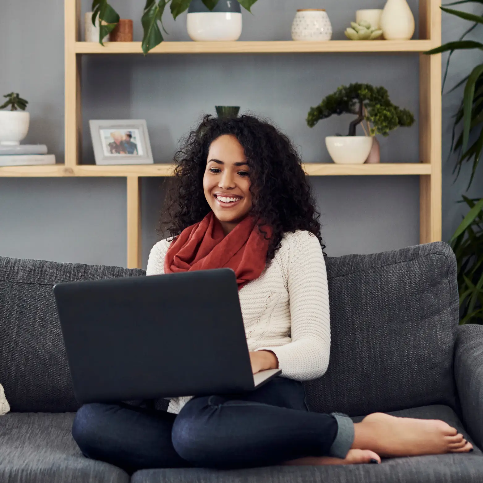 bipoc woman lounging on couch while sending her resume and cover letter to Unstuck Therapy