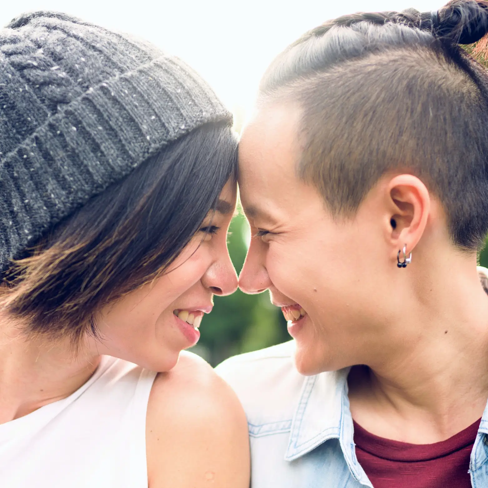 gender queer couple lesbians smiling happy touching noses in love